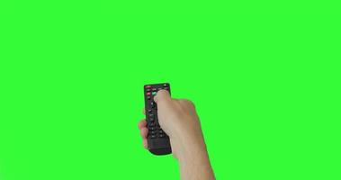mano masculina aislada con el control remoto de la televisión presionando el botón para encender o apagar la televisión. pantalla verde. lugar para su anuncio. paquete de gestos. usando un control remoto sobre el fondo de la clave de croma. punto de vista