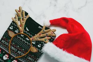 Merry Christmas. Top view of christmas sweater with bright Christmas toy deer antlers and and Santa's hat photo