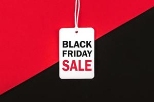 Black friday.Sale tag with text and the rope hanging on red and black background.Shopping concept photo
