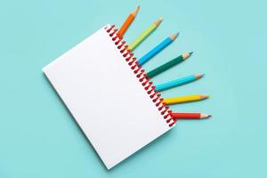 cuaderno espiral con lápices de colores y espacio de copia para su imagen o texto
