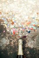 happy New Year. New Years Eve celebration concept background.Champagne bottle with confetti photo