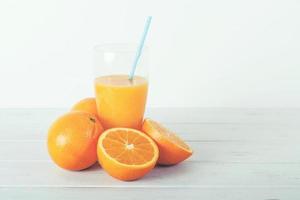 Orange juice in glass on wooden background photo