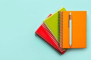 top view of colorful spiral notebooks and blue pen with copy space.Concept back to school
