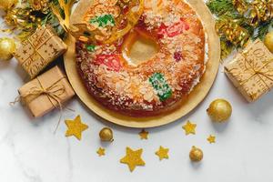 Roscon de reyes with cream and christmas ornaments. Kings day concept spanish three kings cake photo