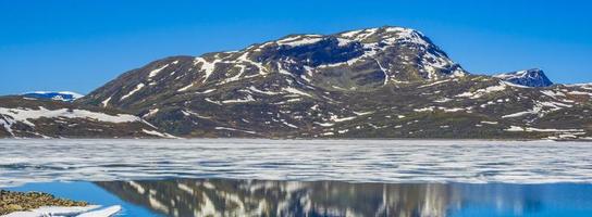 Frozen turquoise lake Vavatn panorama in summer landscape Hemsedal Norway. photo