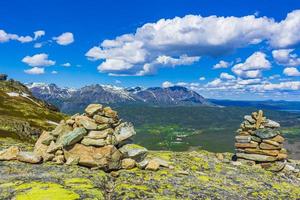 Stacked stones and panorama Norway Hemsedal with snowed in Mountains. photo