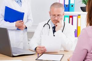 doctor at the table examines the results of his patient's analyzes, doc in medical office photo