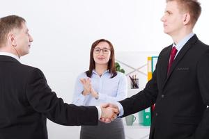 Successful business partnership concept with businessmans handshake. Happy businesswoman applause at office background. Team work businessmen handshaking after profitable deal. Selective focus. photo