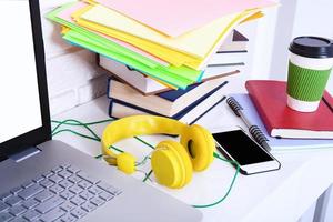 Cup of coffee on modern workspace with electronic devices and copy space. Selective focus photo