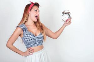 smiling Young womanl with an alarm clock photo