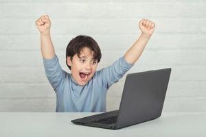 Happy child with laptop computer photo