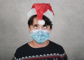 Merry Christmas,funny child with medical mask wearing Santa Claus Hat photo