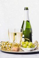 New Years Eve celebration concept background. Champagne with glass and grapes photo