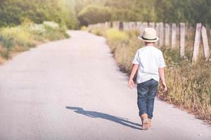 child walking on a road photo