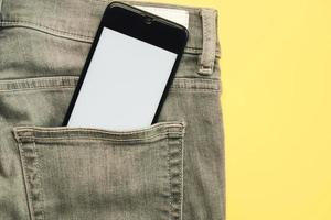 smartphone with white screen in gray jeans pocket photo