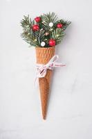 Christmas concept background. Fir branches with Christmas decorations in ice cream cone photo