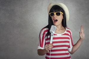 Young woman holding a microphone singing photo