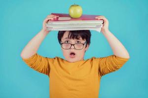 little boy with green apple and books photo