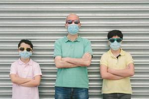 father with his sons wearing medical mask and sunglasses photo