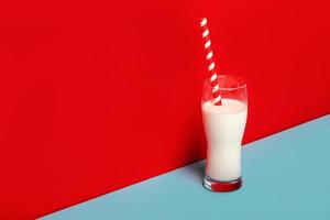 Glass of milk and a red and white drinking straw photo