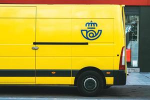 Yellow delivery van of Correos,the Mail Spanish postal company delivering on a public street photo