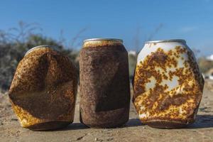 latas oxidadas, lata de bebida oxidada, lata de refresco oxidada, lata oxidada tirada en el campo, lata oxidada, lata oxidada vieja al aire libre, basura foto