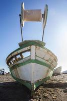 old abandoned wooden boat on the beach, an old shipwreck boat abandoned stand on beach or Shipwrecked off the coast of Mediterranean Sea photo