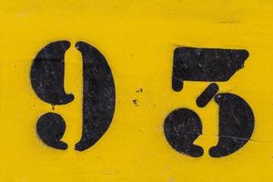 black number 93 stencil painted on yellow background photo