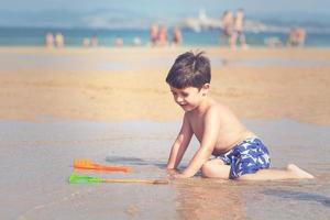 niño jugando en la playa foto