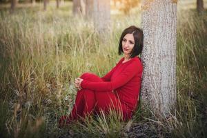 thoughtful woman sitting in the forest photo