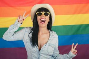 Beautiful young happy woman on rainbow flag background photo