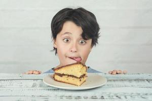 hungry child eating piece of cake photo