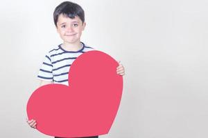 niño feliz con un corazón rojo foto