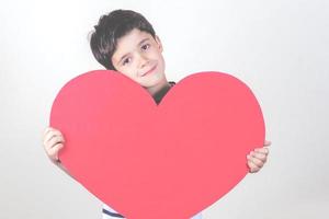 niño feliz con un corazón rojo foto