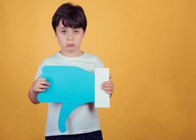 sad boy with a big dislike on yellow background photo