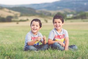 smiling brothers sitting in the field photo