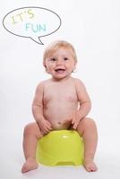 Smiling baby sitting on potty photo