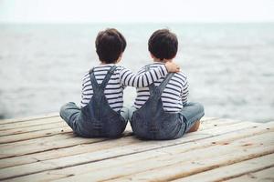 Brothers sitting at waterfront photo