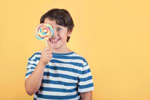 funny child covering eye with lollipop photo