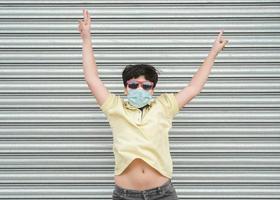 happy kid wearing medical mask jumping on the street photo