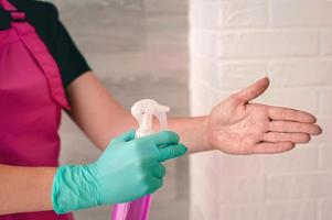 hands in latex gloves holding antiseptic bottle. Antiseptic bottle, safety, covid, cleanliness concept photo