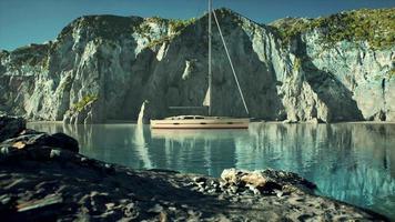 White yacht anchored in a bay with rocky cliffs video