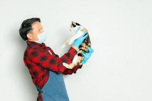 Pet owner affectionately holds a cat of 3 colors. photo