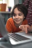 a woman with a child is sitting at a laptop photo