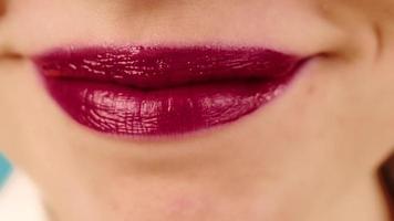 junge Frau professionelles Make-up-Model lächelt fröhlich und zeigt Lippen mit rotem Lippenstift und Glanz im Studio-Zeitlupen-Makro video