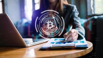 Cryptocurrency hologram, bitcoin, ico theme over hands taking notes background. Concept of blockchain. Multi exposure. photo