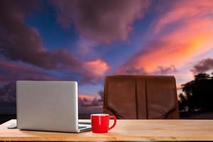 Computer Monitor, Keyboard, coffee cup and Mouse with Blank  is on the work table at the sky mountain river and trees photo