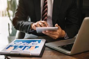 close up of businessman working with laptop computer on wooden desk photo