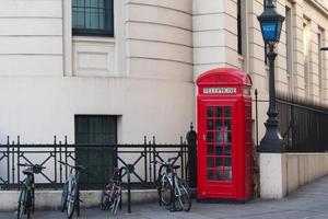 Red british telephone booth and some bicycles. London street, no people photo