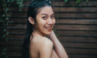 Beautiful young asian woman relaxing while taking a shower photo